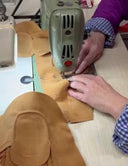 Manos cosiendo unos mocasines de SHUU Barefoot. Calzado barefoot SHUU Hecho en España